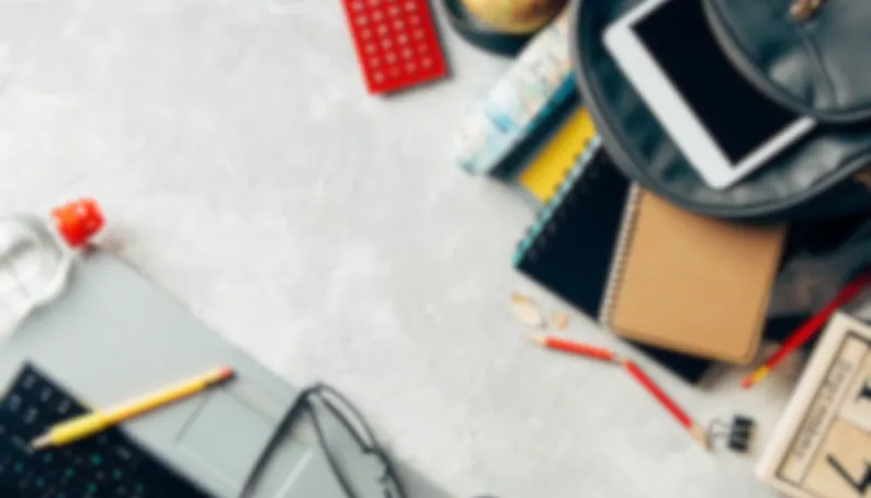 assorted school supplies and laptop arrayed on a desk